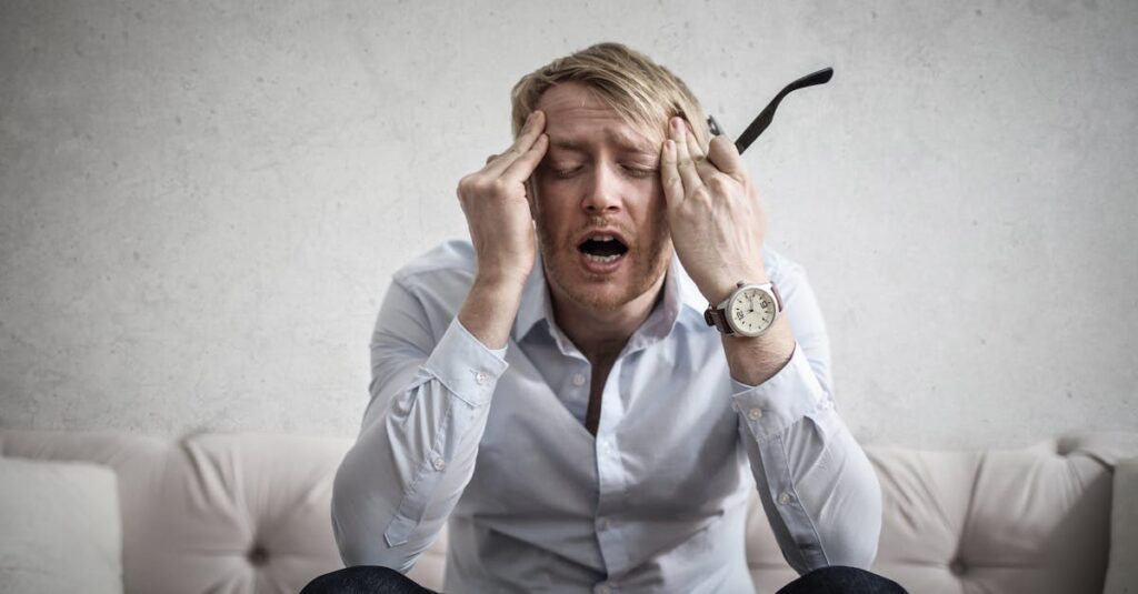 英語学習で挫折した人の悩みや不安を表すイメージ。疲れた表情で机に向かう姿。